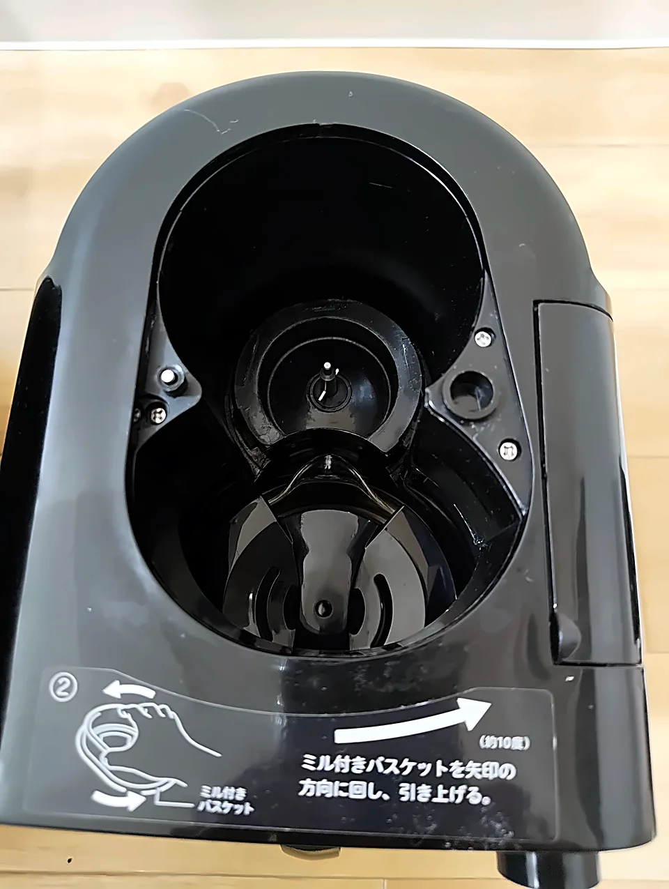 ミル付きバスケットを外したSC-A211の本体。下に「矢印の方向に回し、引き上げる」と読めるラベルが貼られている
